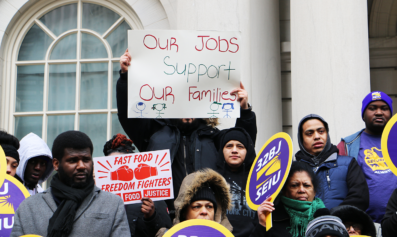 A worker holds a sign that reads "our jobs support our families."