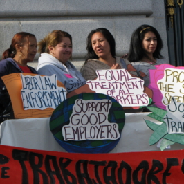 A group people hold signs at worker rally. The signs read "Labor Law Enforcement, Equal Treatment of All Workers, Protect the Social Safety Net, Support Good Employers, and Jobs + Training"