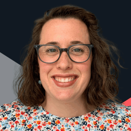 Headshot of 30-something white woman wearing glasses, smiling, looking directly at the camera.