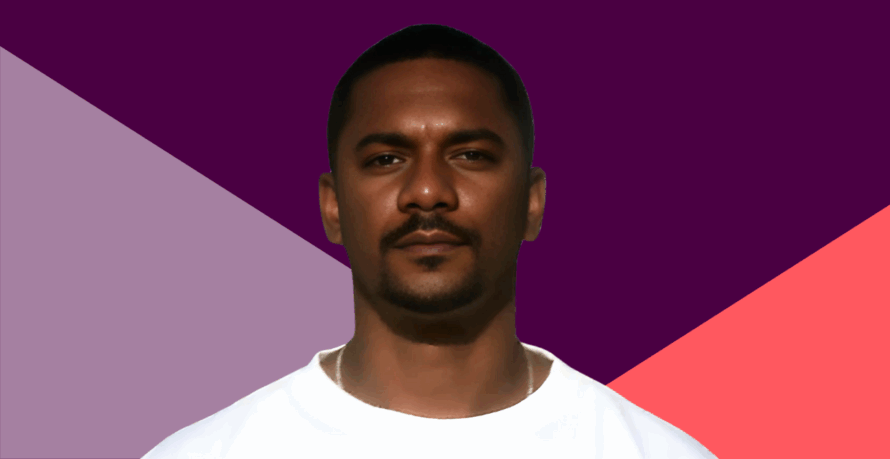 A portrait of a Black man wearing a white t-shirt. against a purple and coral angled background.