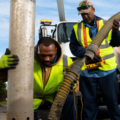 Photo credit: AFSCME, Two workers from the American Federation of State, County and Municipal Employees (AFSCME) performing a task with a large hose and a truck.